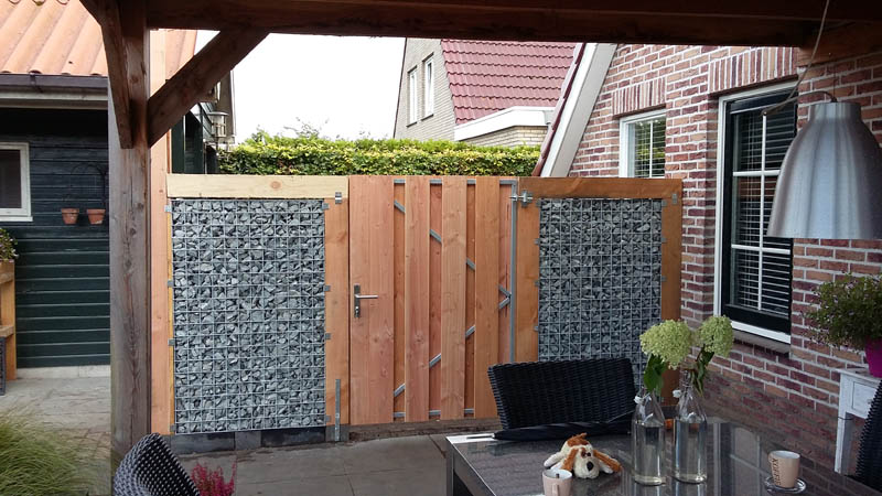 Schanskorven en houten poort onder een overkapping